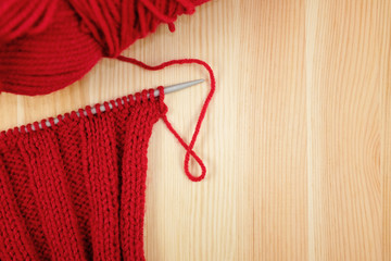 Red knitting in rib stitch with a ball of yarn