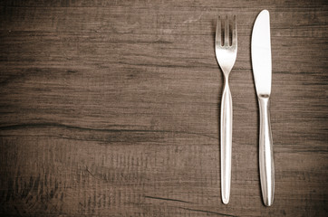 Braun getontes Holz mit Gabel und Messer