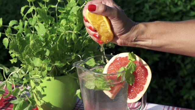 lemon squizing into the jug of water, slow motion shot at 480fps