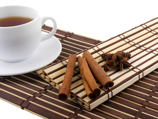 tea cup with cinnamon and star anis on bamboo background