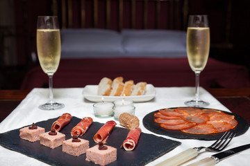 romantic dinner with champagne and Spanish ham in the bedroom
