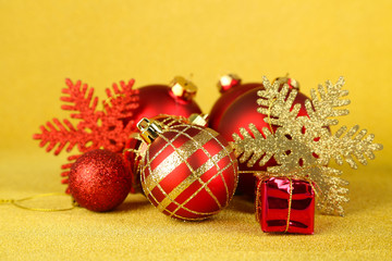 Christmas balls and small gift on yellow background
