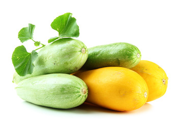 Raw yellow and green zucchini with leaves, isolated on white