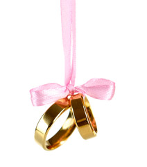 Wedding rings tied with ribbon isolated on white