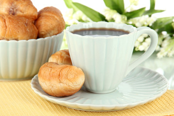 Tasty croissants and cup of coffee on table on white background