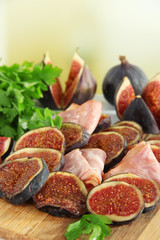 Tasty figs with ham on table