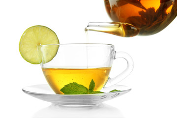 Pouring green tea into cup isolated on white