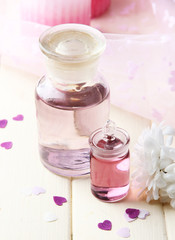 Obraz na płótnie Canvas Glass bottle with color essence, on wooden background