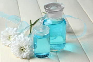 Glass bottles with color essence, on wooden background