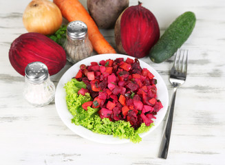 Beet salad on plate on wooden table