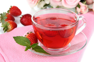 Delicious strawberry tea on table close-up