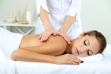 Fototapeta na wymiar Beautiful young woman having back massage close up