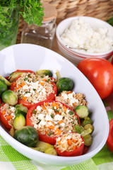 Stuffed tomatoes in bowl on wooden table close-up
