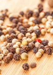 mixed peppercorns on wooden board