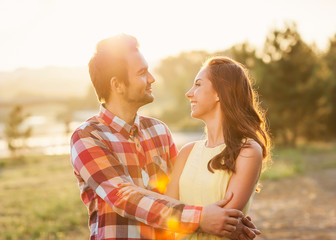 Young couple in love walking in the autumn park near the river.