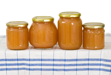 Homemade apple sauce in glass jars on the kitchen linen