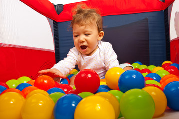 Fototapeta na wymiar Happy baby playing with balls