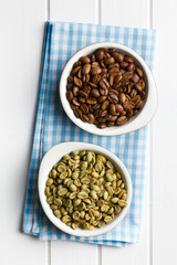 roasted and unroasted coffee beans in ceramic bowls