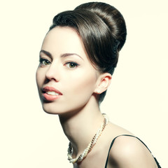 Retro portrait of a smiling beautiful woman with pearl necklace