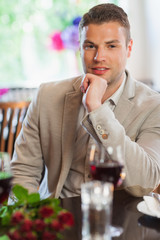 Smiling handsome man waiting for his girlfriend at restaurant