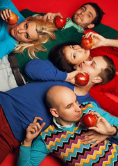 Fototapeta na wymiar Picnic. Five stylish close friends lying and eating apples