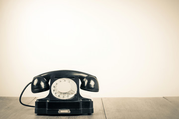 Old retro telephone on table sepia photo