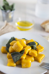 delicious pumpkin gnocchi with sage leaves and olive oil, vegan