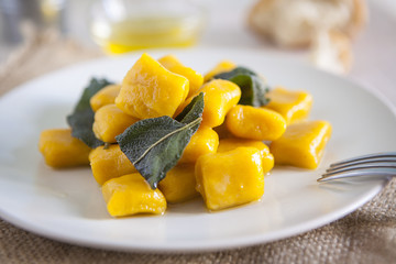 delicious pumpkin gnocchi with sage leaves and olive oil, vegan