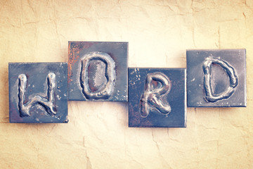 The word "WORD" made from metal letters on an old vintage paper