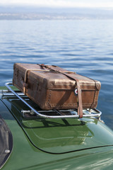 Back of a vintage sports car with an old leather case