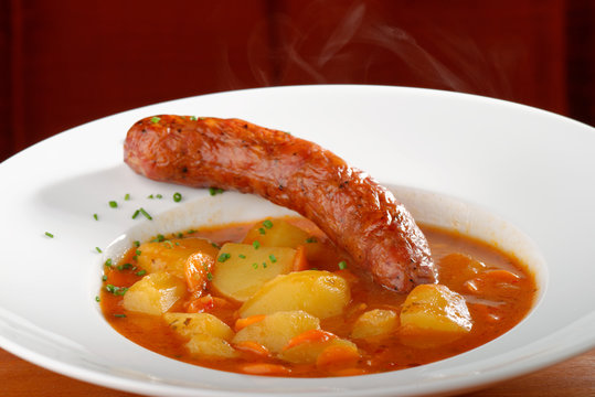 Wurst goulash soup with meat sausage and potatoes garnished