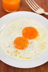 fried eggs in plate and juice
