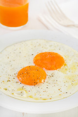 fried eggs on plate and juice
