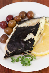 fish with olives and lemon on plate