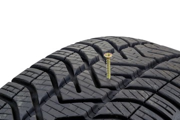 A screw stuck in a car tyre on a white background © Mister G.C.