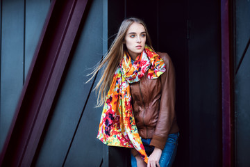 Beautiful fashion woman wearing leather coat and scarf posing