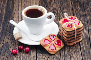 Fototapeta na wymiar Cup of hot coffee and cookies tied ribbon