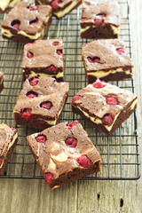 Cheesecake brownies with raspberry on a cooling rack