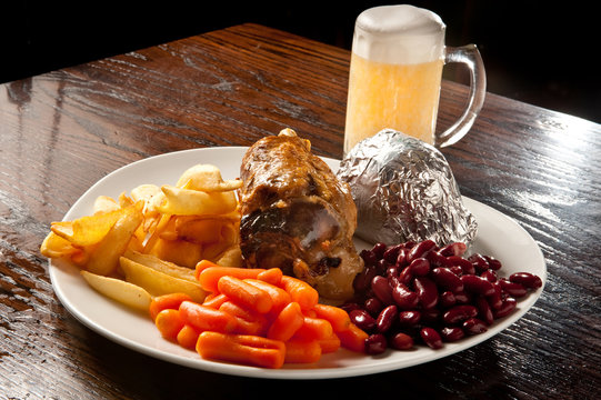 stinco di maiale con contorni e patata al cartoccio