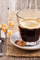 Black coffee in a glass with crystal sugar