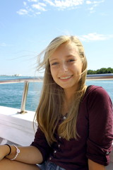 Cheerful young blonde girl on ship at sea