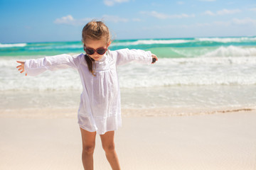 Fototapeta na wymiar Adorable little girl having fun on an exotic white beach at