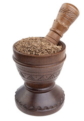 Cumin on wooden mortar on white background