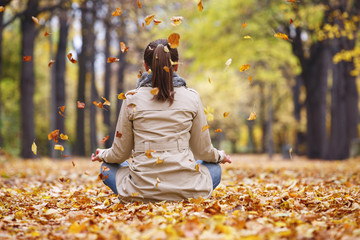 Woman meditator in the autumn park