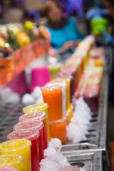 Plastic Cups of Colorful Fruit Juices in a Market