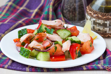 Fresh salmon salad with cucumbers, tomatoes, capsicum and onion