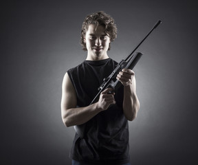 Fototapeta na wymiar Militant young man with a gun.