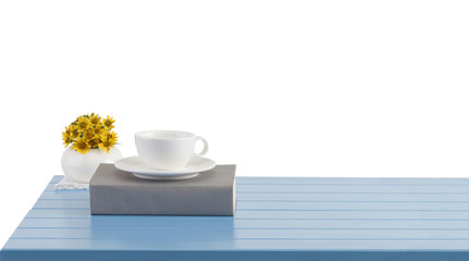 A coffee cup and book on the blue wooden table