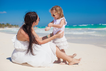 Adorable little girl having fun with her mother on the white