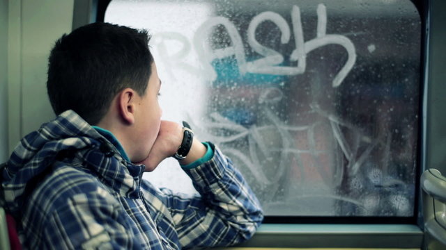 Young boy riding bus and looking out the window